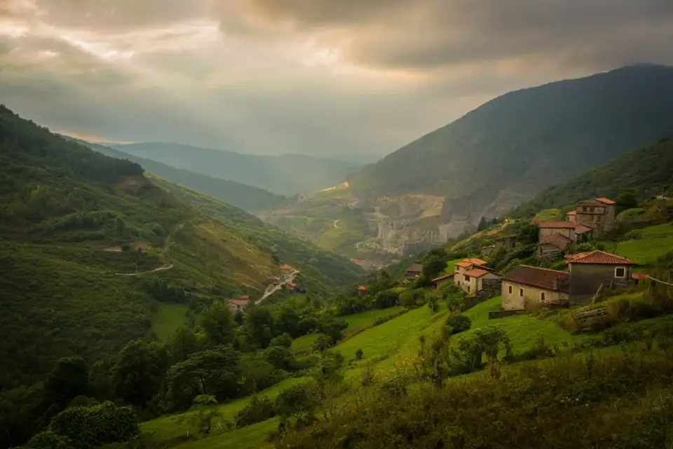 Vallée verdoyante du Valle de Turón dans les Asturies, Espagne, avec des maisons en pierre et les montagnes de la Cordillère Cantabrique en arrière-plan