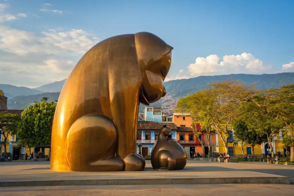 Sculpture monumentale de Fernando Botero sur la Plaza Botero à Medellín en Colombie, place publique ensoleillée avec arbres tropicaux et architecture coloniale