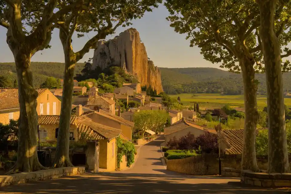 Le village de Cotignac au pied de sa falaise de tuf dans le Haut-Var, maisons ocre et cours Gambetta bordé de platanes en Provence verte